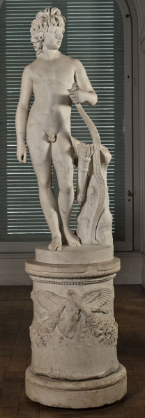 Henryk Lubomirski jako Amor. marmurowy posąg Henryka Lubomirskiego przedstawia go jako Amora, boga miłości. Nagi chłopiec stojący w kontrapoście trzyma w ręku łuk wsparty o pień drzewa. Do pnia przywiązany jest wstęgą kołczan ze strzałami. Rzeźba na wysokim okrągłym postumencie. W tle widoczne okno z zielonymi żaluzjami.