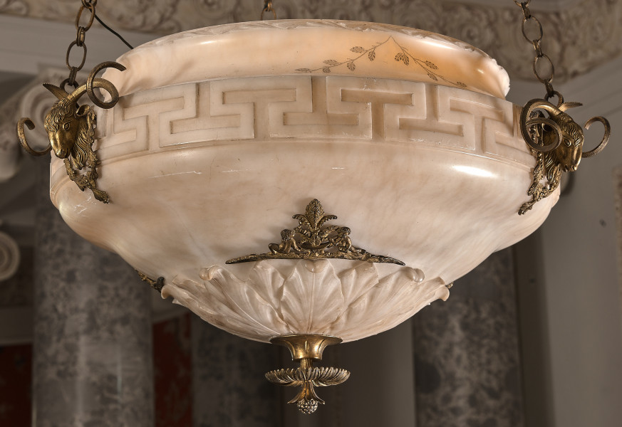 Ampla alabastrowa. Fragment misy dekorowanej mosiężnymi głowami kozłów.