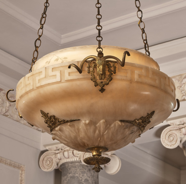 Ampla alabastrowa. Fragment misy dekorowanej mosiężnymi głowami kozłów. Widoczne łańcuchy i fragment sufitu.