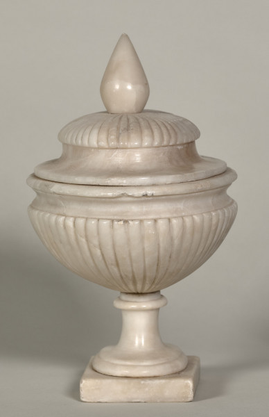 Waza alabastrowa, owalna z pokrywą zakończoną sterczyną. Wąski bok.