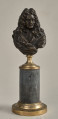 Jean Baptiste Racine. Brązowe, miniaturowe popiersie przedstawia go w starszym wieku, w peruce. Popiersie ustawione jest na podstawie złożonej z brązowego, złoconego cokoliku, cylindrycznego marmurowego trzonu (brak metalowego łańcuszka) i brązowej, złoconej bazy. Przód