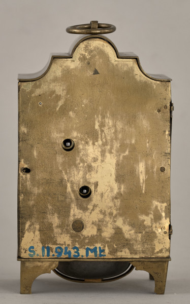 Tylna, płaska ścianka zegara kominkowego. Złocona, bez dekoracji. Widoczne otwory do nakręcania.