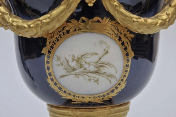fragment brzuśca rewersu - emblemat złożony z gałązki i liścia palmy, na których siedzą 2 zwrócone ku sobie dziobami gołębie, z tyłu widoczna jest płonąca pochodnia