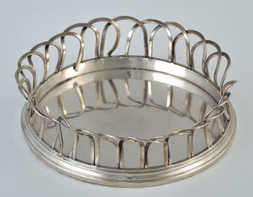 Srebrny koszyczek pod karafkę w ujęciu z góry.