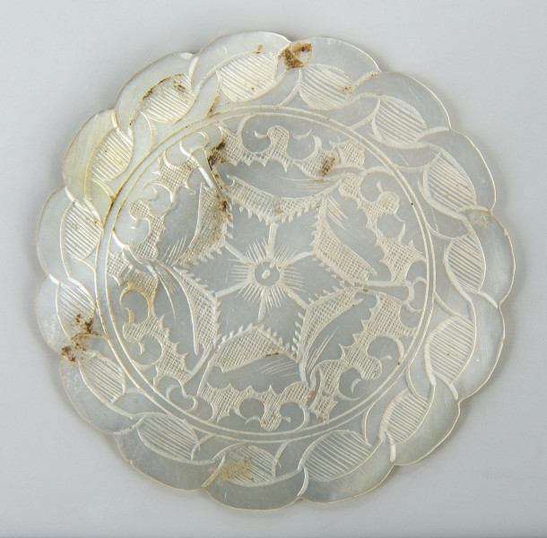 plakietka w formie koła z pofalowanym brzegiem