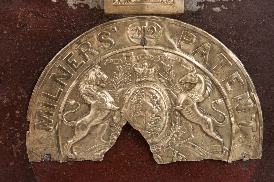 detal - górna połowa okrągłej plakiety z nazwą wytwórcy i herbem Wlk. Brytanii na froncie