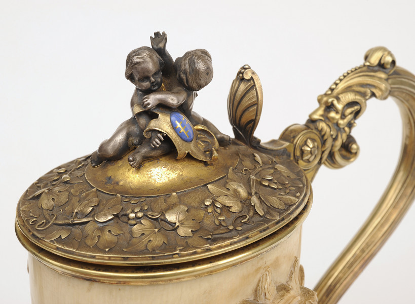 fragment - ujęcie lekko z góry na pokrywę z dwoma puttami i tarczą herbową o dwóch Pilawach