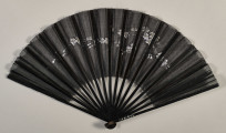 Czarny, otwarty wachlarz z widocznym wzorem kwiatowym ze srebrnej nici. Odwrocie