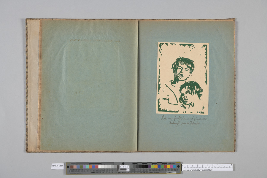 Ujęcie od góry. Rozłożony zeszyt z grafiką naklejoną na prawą kartę. Grafika przedstawia  dwójkę wtulonych w siebie dzieci.