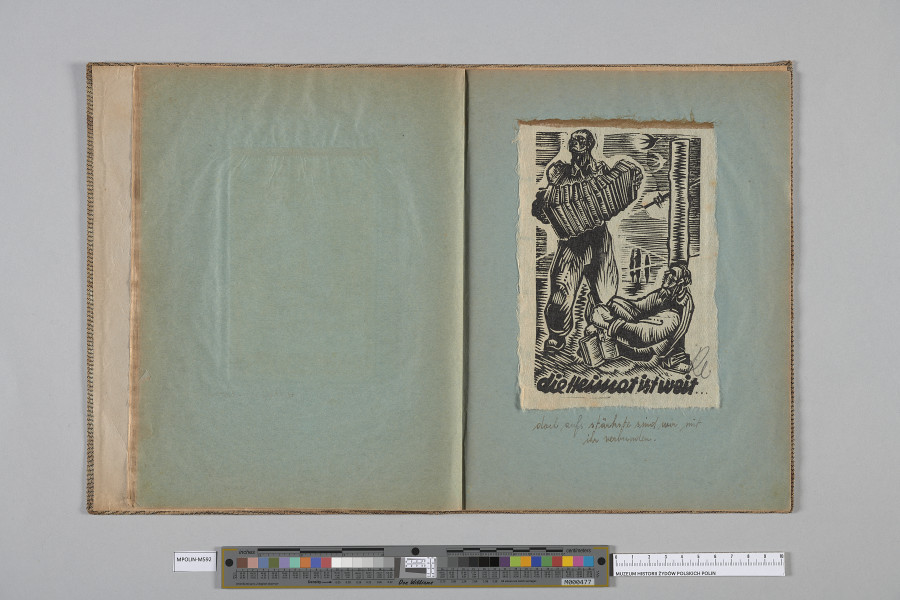 Ujęcie od góry. Rozłożony zeszyt z grafiką naklejoną na prawą kartę. Grafika przedstawia  dwóch mężczyzn, jeden stojący, z akordeonem, drugi, po prawej, półleżący, z książką.