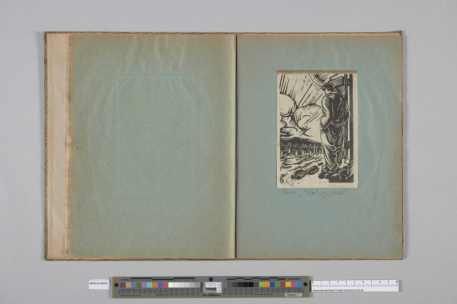 Ujęcie od góry. Rozłożony zeszyt z grafiką naklejoną na prawą kartę. Grafika przedstawia  mężczyzne stojącego w otwartych drzwiach, widocznego od tyłu.