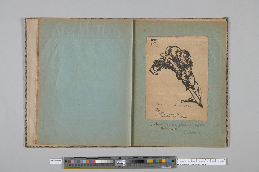 Ujęcie od góry. Rozłożony zeszyt z grafiką naklejoną na prawą kartę. Grafika przedstawia nacierający mężczyzna z bagnetem.