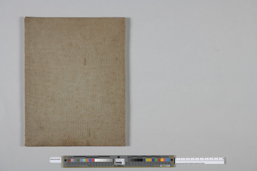 Ujęcie od góry. Złożony tył oprawionego w płótno zeszytu.