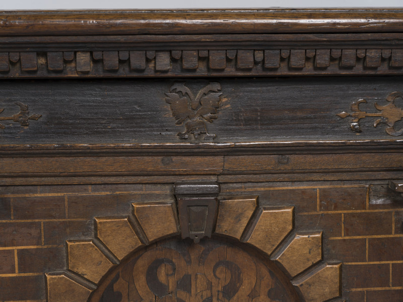 zbliżenie na rzeźbioną dekorację z przodu skrzyni - motywy architektoniczne