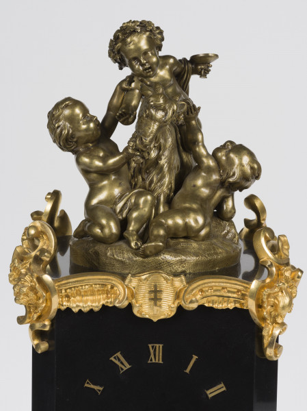 zbliżenie na zwieńczenie z grupą figuralną z brązu patynowanego - mały Bachus w wieńcu winorośli z kielichem w dłoni siedzący na koźle, bawi się z dwoma puttami