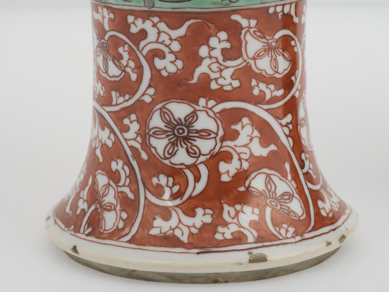 zbliżenie na dekorację z białym motywem roślinnym na czerwonym tle w dolnej części naczynia