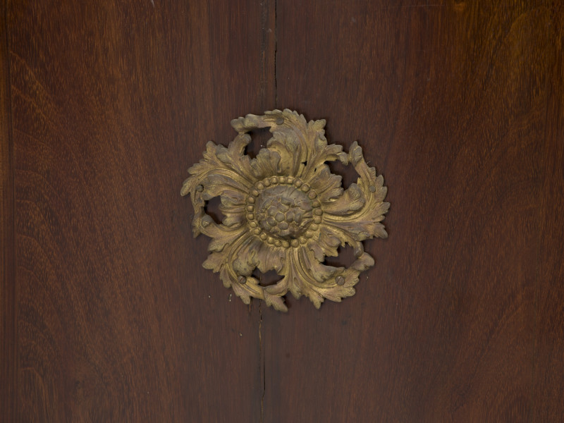 zbliżenie na dekorację z brązu w formie wirującej rozety roślinnej na prawych drzwiczkach