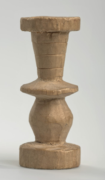 Ujęcie z boku [1]. Ze względu na swój okrągły kształt kolejne ujęcia z boku nie różnią się między sobą znacząco. Wieża została wykonana ręcznie z jednego kawałka jasnego drewna. Na całej powierzchni widoczne są ślady rzeźbienia przy pomocy noża. Obiekt w kolorze naturalnego drewna (nie został pomalowany, ani polakierowany). Od spodu widoczne oznaczenie składające się z dwóch przecinających się ze sobą linii („X”), które umożliwia podzielenie bierek pomiędzy dwóch graczy - wszystkie bierki są jednakowego koloru. Wieża składa się ze spłaszczonej podstawy w formie krążka, środkowej części w formie walca szerszego po środku, spłaszczonego cylindrycznego elementu, który zwęża się stopniowo ku górze oraz ku dołowi (przypominając dwa połączone ze sobą talerze, z których każdy skierowany jest dnem do zewnątrz) oraz zwieńczenia w kształcie kielicha, ozdobionego przy pomocy linii (żłobień).