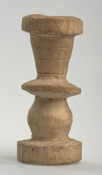 Ujęcie z boku [2]. Ze względu na swój okrągły kształt kolejne ujęcia z boku nie różnią się między sobą znacząco. Wieża została wykonana ręcznie z jednego kawałka jasnego drewna. Na całej powierzchni widoczne są ślady rzeźbienia przy pomocy noża. Obiekt w kolorze naturalnego drewna (nie został pomalowany, ani polakierowany). Wieża składa się ze spłaszczonej podstawy w formie krążka, środkowej części w formie walca szerszego po środku, spłaszczonego cylindrycznego elementu, który zwęża się stopniowo ku górze oraz ku dołowi (przypominając dwa połączone ze sobą talerze, z których każdy skierowany jest dnem do zewnątrz) oraz zwieńczenia w kształcie kielicha, ozdobionego przy pomocy linii (żłobień).