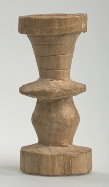 Ujęcie z boku [4]. Ze względu na swój okrągły kształt kolejne ujęcia z boku nie różnią się między sobą znacząco. Wieża została wykonana ręcznie z jednego kawałka jasnego drewna. Na całej powierzchni widoczne są ślady rzeźbienia przy pomocy noża. Obiekt w kolorze naturalnego drewna (nie został pomalowany, ani polakierowany). Od spodu widoczne oznaczenie składające się z dwóch przecinających się ze sobą linii („X”), które umożliwia podzielenie bierek pomiędzy dwóch graczy - wszystkie bierki są jednakowego koloru. Wieża składa się ze spłaszczonej podstawy w formie krążka, środkowej części w formie walca szerszego po środku, spłaszczonego cylindrycznego elementu, który zwęża się stopniowo ku górze oraz ku dołowi (przypominając dwa połączone ze sobą talerze, z których każdy skierowany jest dnem do zewnątrz) oraz zwieńczenia w kształcie kielicha, ozdobionego przy pomocy linii (żłobień).