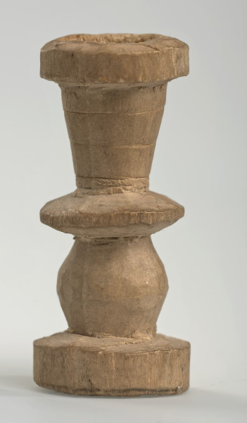 Ujęcie z boku [4]. Ze względu na swój okrągły kształt kolejne ujęcia z boku nie różnią się między sobą znacząco. Wieża została wykonana ręcznie z jednego kawałka jasnego drewna. Na całej powierzchni widoczne są ślady rzeźbienia przy pomocy noża. Obiekt w kolorze naturalnego drewna (nie został pomalowany, ani polakierowany). Wieża składa się ze spłaszczonej podstawy w formie krążka, środkowej części w formie walca szerszego po środku, spłaszczonego cylindrycznego elementu, który zwęża się stopniowo ku górze oraz ku dołowi (przypominając dwa połączone ze sobą talerze, z których każdy skierowany jest dnem do zewnątrz) oraz zwieńczenia w kształcie kielicha, ozdobionego przy pomocy linii (żłobień).