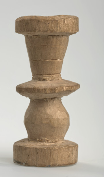 Ujęcie z boku [1]. Ze względu na swój okrągły kształt kolejne ujęcia z boku nie różnią się między sobą znacząco. Wieża została wykonana ręcznie z jednego kawałka jasnego drewna. Na całej powierzchni widoczne są ślady rzeźbienia przy pomocy noża. Obiekt w kolorze naturalnego drewna (nie został pomalowany, ani polakierowany). Wieża składa się ze spłaszczonej podstawy w formie krążka, środkowej części w formie walca szerszego po środku, spłaszczonego cylindrycznego elementu, który zwęża się stopniowo ku górze oraz ku dołowi (przypominając dwa połączone ze sobą talerze, z których każdy skierowany jest dnem do zewnątrz) oraz zwieńczenia w kształcie kielicha, ozdobionego przy pomocy linii (żłobień).