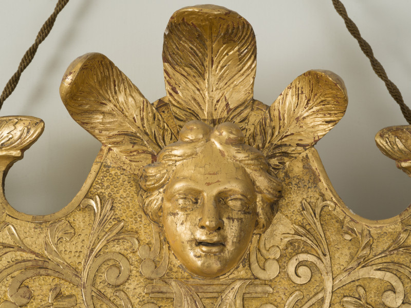 zbliżenie na rzeźbioną dekorację ramy w formie kobiecej głowy w pióropuszu