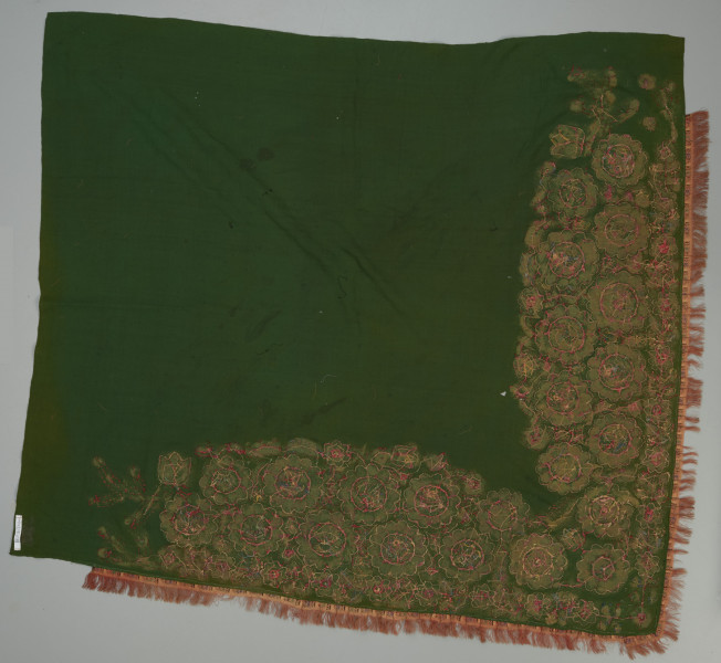 zielona chusta z, haftem z motywami kwiatowymi, cekinami i frędzlami - Ujęcie z tyłu; Chusta kwadratowa, z wełnianej, ciemnozielonej tkaniny, którą obszyto pasmanteryjną lamówką z frędzlami.