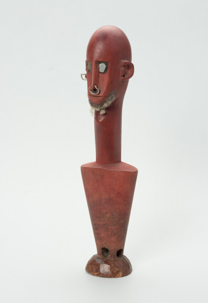 lalka teatralna Ton Fa (opiekun/patron męskiej części Kamalen Ton) - Ujęcie z przodu skosem w lewo. Figurka z drewna pomalowana na kolor czerwony, przedstawiająca postać męską  z długą szyją i odstającymi uszami. Nos długi, wąski, na końcu z przymocowaną na wylot metalową cienką obręczą. Oczy blisko nosa, z przymocowanymi metalowymi blaszkami. Krótka broda z jasnego włosia. Korpus w formie stożka odwróconego dnem do góry. Zamiast nóg okrągła mała podstawa. Nad nią, na środku wywiercony na wylot niewielki otwór.