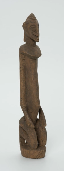 drewniana, rzeźbiona figura - Ujęcie z przodu, z prawej strony. Drewniana, rzeźbiona figura przedstawiająca klęczącą postać.