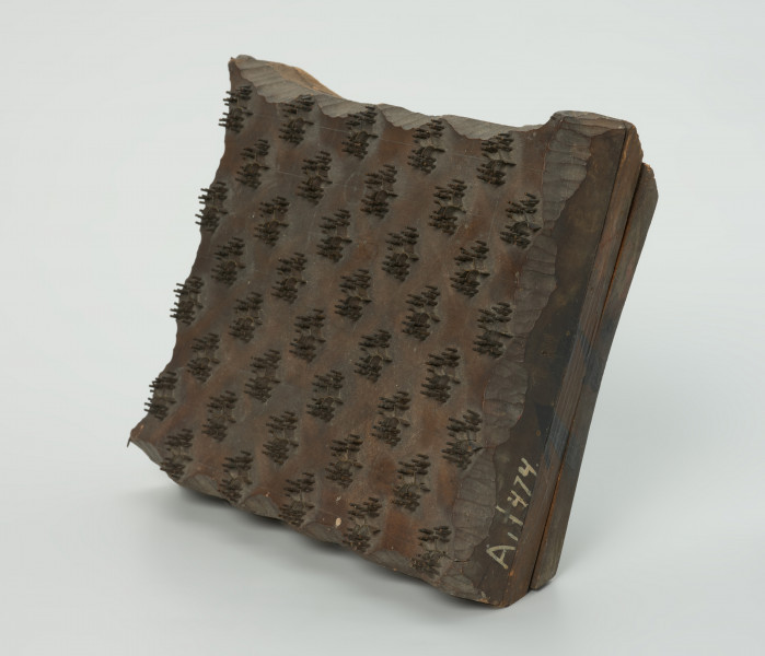 sprzęt do drukowania i grafiki, matryca drukująca - Ujęcie przodu skosem w prawą stronę. Matryca do drukowania tkanin z wykonanym z nabitych w drewno mosiężnych sztyfcików i blaszek ornamentem o motywie roślinnym.