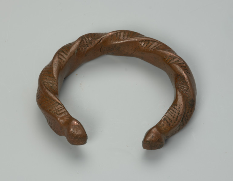 biżuteria, bransoleta - Ujęcie z przodu z dołu. Otwarta, miedziana, owalna bransoleta pokryta gęstym wzorem punktowym.