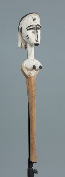 lalka teatralna: Mèrè - Ujęcie z przodu skosem w prawą stronę. Marionetka przedstawiająca popiersie kobiece o jasnej, białej karnacji. Podłużna głowa okolona włosami z włóczki o wyraźnie zaznaczonych brwiach.