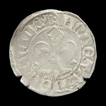 MNS/H/858/5 Srebrna moneta pomorska gruby fenig - Ujęcie awersu. Cienka moneta okrągła, o nieregularnych kształtach. W polu otoczonym perełkowym łańcuszkiem lilia. Na brzegu napis.