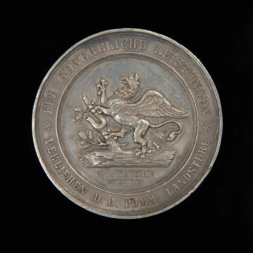 medal nagrodowy - Ujęcie awersu. Medal z wizerunkiem wspiętego gryfa na powalonym pniu i żaglowca na falach. Na awersie wspięty gryf na powalonym pniu dębu, z którego wyrastają ulistnione gałęzie. U dołu grawerunek. W otoku napis za osiągniecia gospodarcze – nadane przez Pomorską Izbę Krajową.