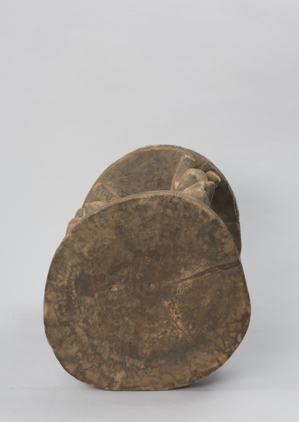 rzeźba - Ujęcie z góry. Drewniany stół. Okrągły blat połączony z podstawą o tym samym kształcie za pomocą czterech rzeźbionych postaci.