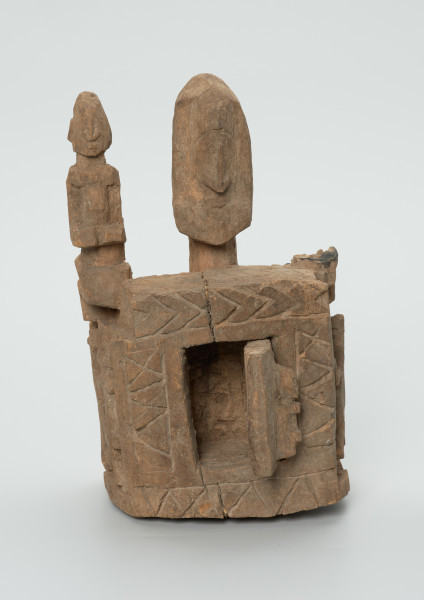 drewniane pudełko na fetysz - Ujęcie z przodu z otwartymi drzwiczkami. Drewniane pudełko, dekorowane płaskorzeźbami, w środku którego widoczne są drzwiczki.