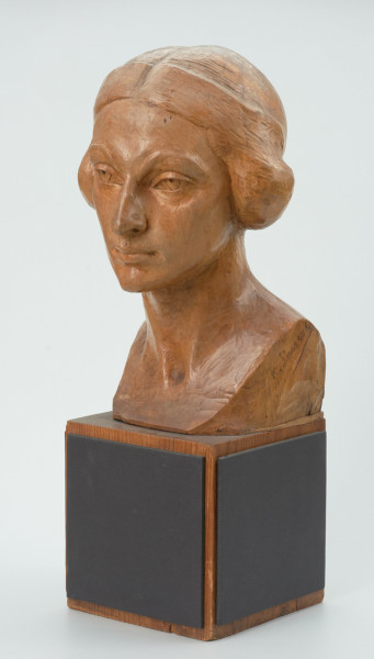 głowa - Ujęcie z przodu skosem w lewą stronę; Głowa młodej kobiety. Twarz owalna, podbródek spiczasty, duże nieco skośne oczy pod wyrazistymi łukami brwi. Krótkie przylegające włosy z przedziałkiem pośrodku.