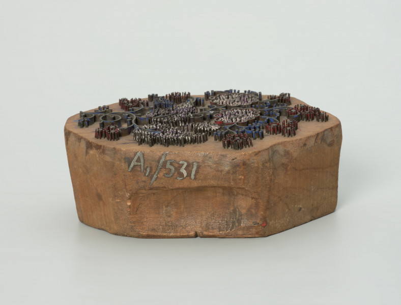 sprzęt do drukowania i grafiki, matryca drukująca - Ujęcie w poziomie krótszego boku przodu matrycy. Matryca do drukowania tkanin z wykonanym z nabitych w drewno mosiężnych sztyfcików i blaszek ornamentem o motywie roślinnym.