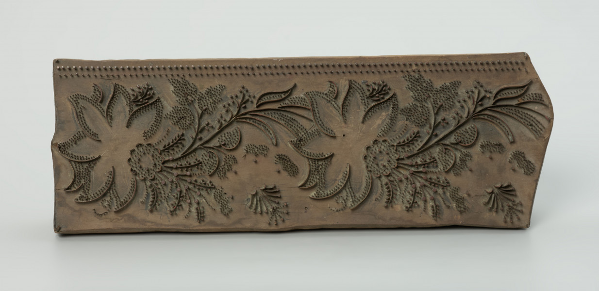 sprzęt do drukowania i grafiki, matryca drukująca - Ujęcie z przodu. Matryca do drukowania tkanin z wykonanym z nabitych w drewno mosiężnych sztyfcików i blaszek ornamentem o motywie roślinnym.