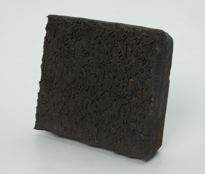 sprzęt do drukowania i grafiki, matryca drukująca - Ujęcie przodu skosem w prawą stronę. Matryca do drukowania tkanin z wykonanym częściowo w drewnie i częsciowo z mosiężnych sztyfcików w nie nabitych, ornamencie o motywie roślinnym.