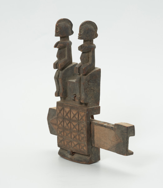 drewniany zamek do drzwi - Ujęcie z przodu, z prawej strony. Drewninany zamek do drzwi, z wyrzeźbionymi dwoma postaciami człowieka oraz z dekoracją w formie ornamentu.