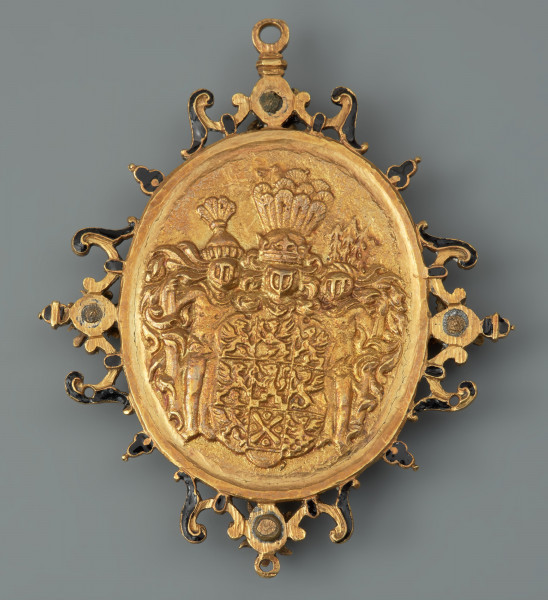 medalion historyczny; medal pamiątkowy - Ujęcie rewersu. Na rewersie dziewięciopolowa tarcza herbowa Pomorza Zachodniego podtrzymywana przez leśnych ludzi trzymających maczugi. Wokół medalionu ażurowe obramienie o motywach roślinno-cęgowych z czterema ośmiopłatkowymi rozetami. U góry i na dole uszka, przy bocznych krawędziach małe otwory.