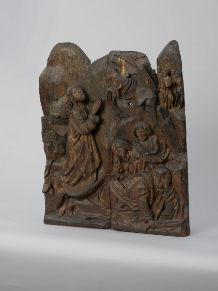 sztuka sakralna, kwatera ołtarza, płaskorzeźba - Ujęcie ze skosu z prawej strony; Płaskorzeźba przedstawiająca Chrystusa modlącego się w ogrodzie Getsemani i śpiących apostołów, na tle skalistego pejzażu. Kwatera lewego skrzydła późnogotyckiego ołtarza pasyjnego z Wkryujścia (Ueckermünde).