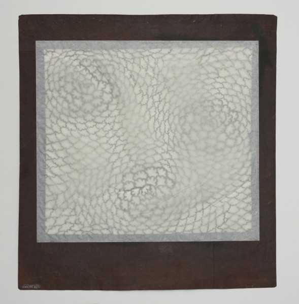 szablon farbiarski katagami; wycinanka; dekoracja - Ujęcie z tyłu. Duży, zabarwiony na brązowo, kwadratowy szablon farbiarski typu jishiro wzmocniony od spodu siatką z ludzkich włosów, przedstawiający motyw trzech stylizowanych peonii.