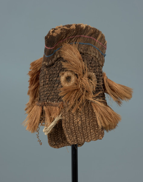 drewniana maska - Ujęcie maski z przodu, z lewej strony. Drewniana, rzeźbiona maska mężczyzny.