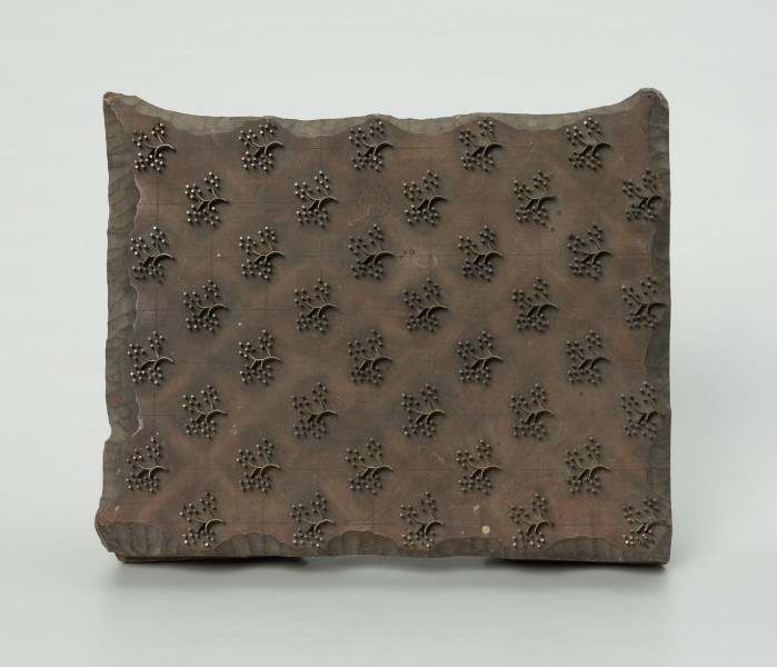 sprzęt do drukowania i grafiki, matryca drukująca - Ujęcie z przodu. Matryca do drukowania tkanin z wykonanym z nabitych w drewno mosiężnych sztyfcików i blaszek ornamentem o motywie roślinnym.