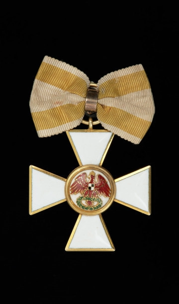 MNS/N/12292 Order Czerwonego Orła III klasy - Ujęcie awersu. Krzyż maltański o ramionach pokrytych białą emalią ze złotą obwódkach po brzegach. Na awersie w środkowym medalionie na białej emalii czerwony orzeł z wieńcem laurowym w szponach.