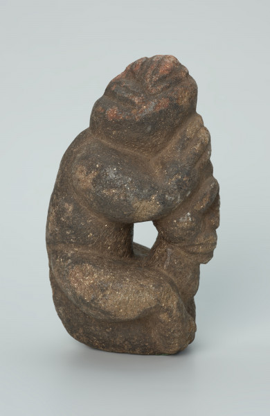 rzeźba; popiersie; Figura kultu zmarłych - Ujęcie prawy bok. Rzeźbione w grafitowobeżowym steatycie popiersie człowieka z jaszczurką, której łapy obejmują głowę i ramiona postaci ludzkiej.