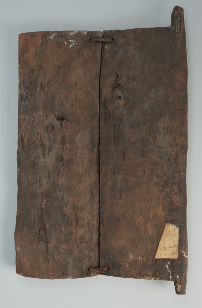 drzwiczki do spichlerza - Ujęcie z tyłu. Drzwiczki do spichlerza wykonane z dwóch desek połączonych żelaznymi klamrami i zaopatrzone w system zawiasów. Całość ozdobiona wyrzeźbionymi wizerunkami przodków.